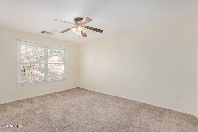 spare room featuring light carpet and ceiling fan