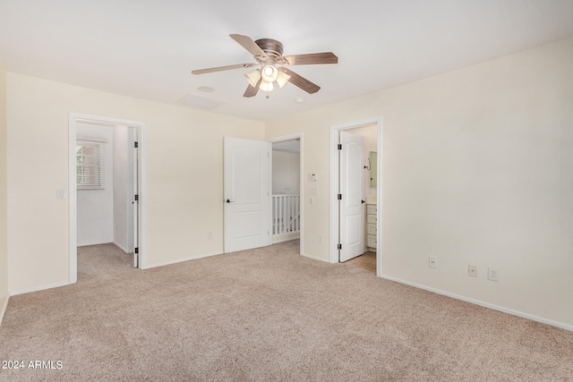 unfurnished bedroom with light carpet, connected bathroom, and ceiling fan