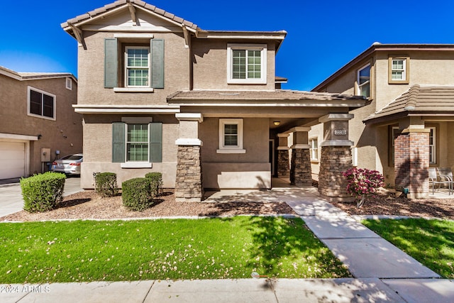 view of front of house with a front yard, a garage, and a porch