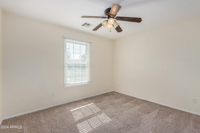 spare room featuring light carpet and ceiling fan