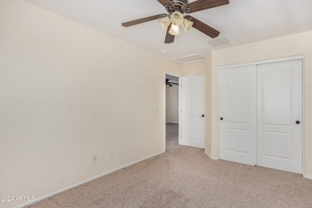 unfurnished bedroom featuring a closet, ceiling fan, and light colored carpet