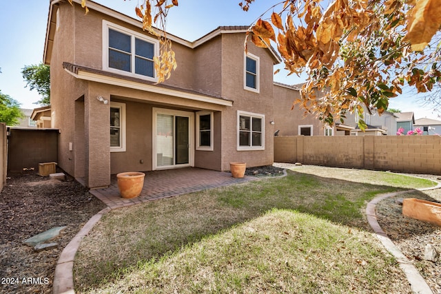 rear view of house featuring a patio area and a lawn