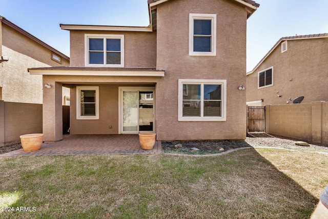 back of property featuring a patio area and a lawn