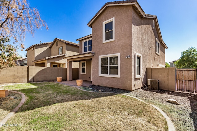 rear view of house featuring a patio, a yard, and central air condition unit