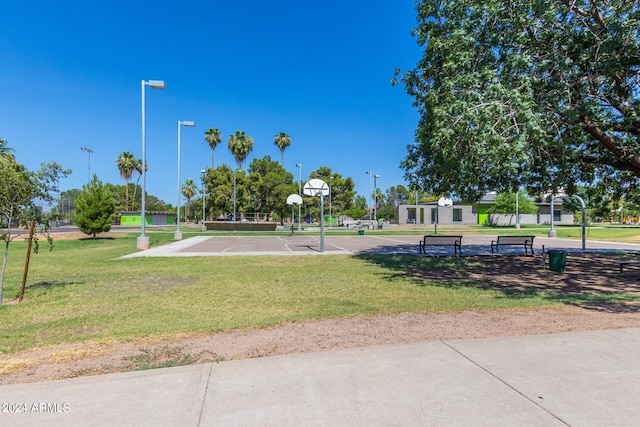 view of community featuring a lawn and basketball hoop