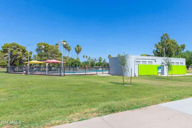 view of community featuring a yard and a swimming pool