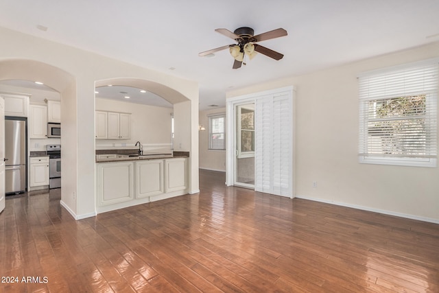 unfurnished living room with ceiling fan and dark hardwood / wood-style flooring