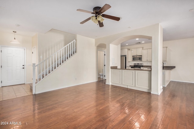 unfurnished living room with light wood-type flooring and ceiling fan