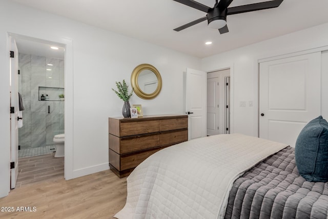 bedroom with ensuite bath, light hardwood / wood-style floors, a closet, and ceiling fan