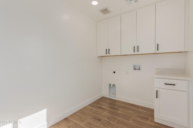 washroom featuring electric dryer hookup, hookup for a washing machine, and cabinets