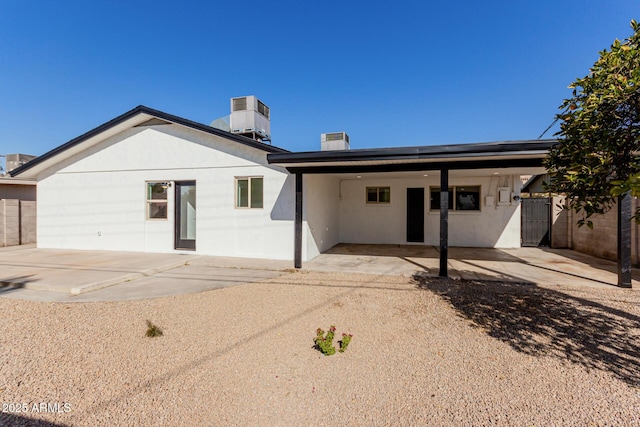 rear view of house featuring cooling unit and a carport