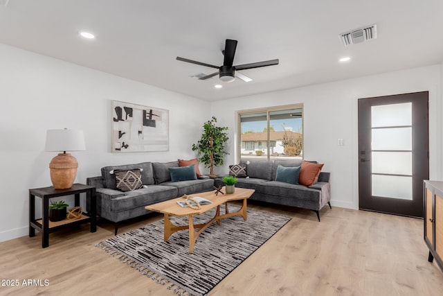 living room featuring light hardwood / wood-style flooring and ceiling fan