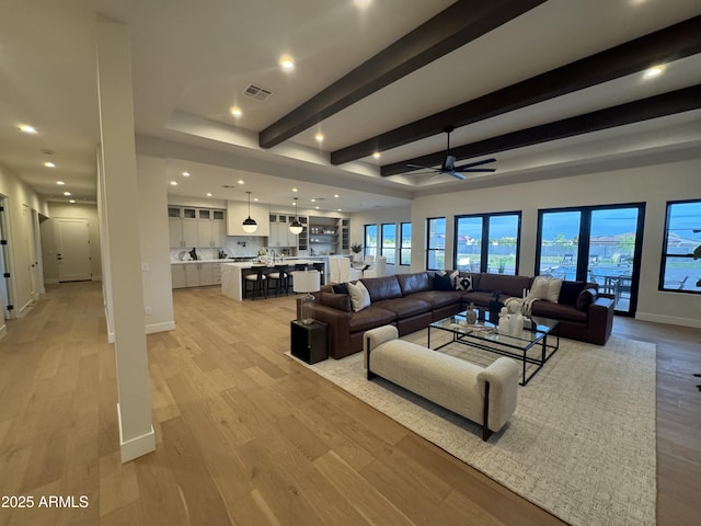 living area with visible vents, beamed ceiling, light wood-style floors, ceiling fan, and recessed lighting