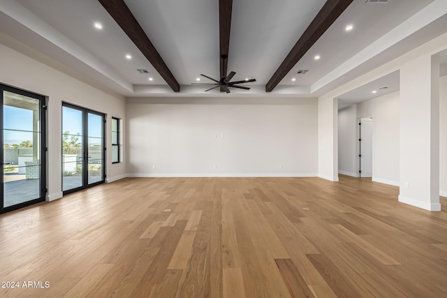 unfurnished living room featuring visible vents, beam ceiling, baseboards, a ceiling fan, and light wood-style flooring