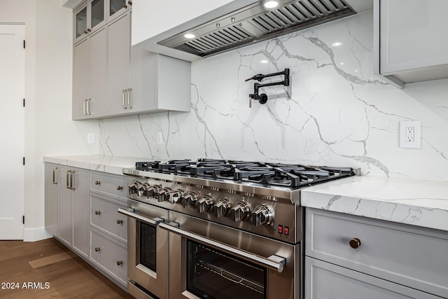 kitchen with decorative backsplash, premium range hood, range with two ovens, and dark hardwood / wood-style flooring