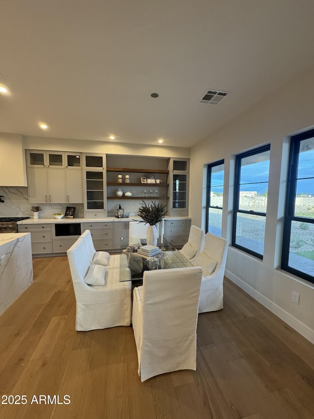 living area featuring recessed lighting, baseboards, visible vents, and wood finished floors
