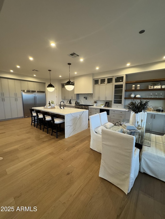 living area featuring recessed lighting, light wood-type flooring, and visible vents