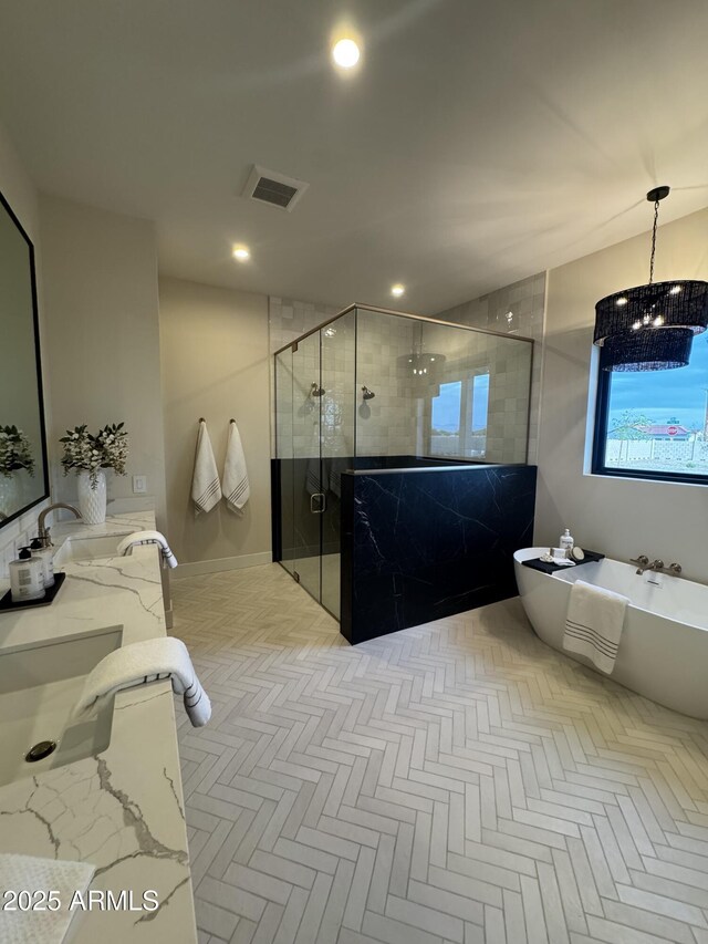 bathroom with visible vents, vanity, a soaking tub, a chandelier, and a shower stall
