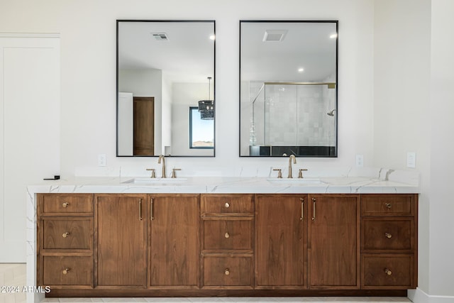 full bath featuring double vanity, visible vents, a shower stall, and a sink