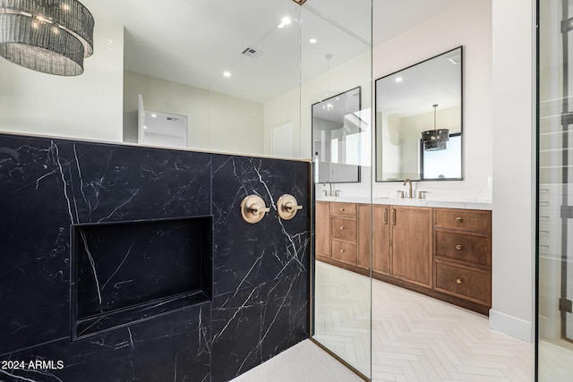 full bath featuring double vanity, a marble finish shower, a sink, and visible vents