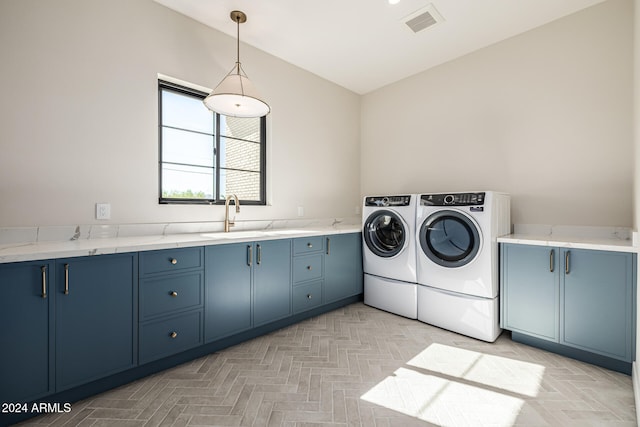 laundry room featuring sink, washer and dryer, and cabinets