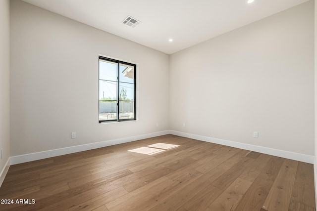 unfurnished room with baseboards, recessed lighting, hardwood / wood-style floors, and visible vents