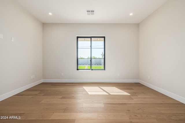 spare room featuring recessed lighting, baseboards, light wood-type flooring, and visible vents