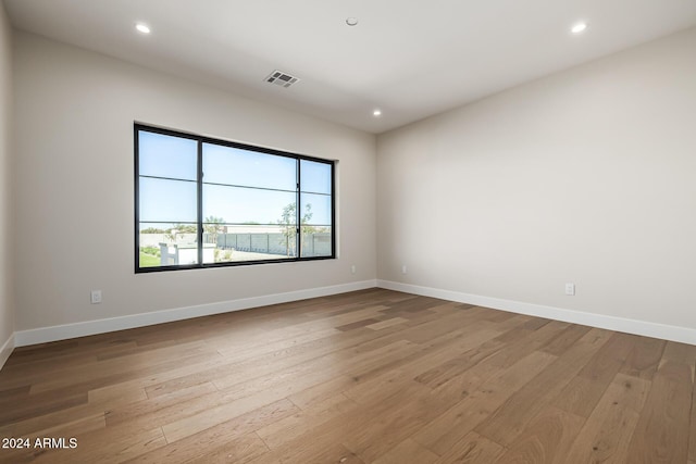 unfurnished room with recessed lighting, visible vents, and hardwood / wood-style floors