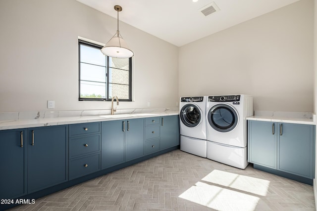 laundry area with cabinet space, a sink, washer and clothes dryer, and visible vents