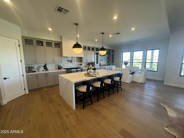 kitchen with light wood-style floors, a spacious island, and visible vents