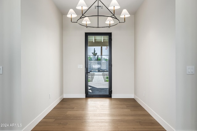 entrance foyer with a chandelier and wood-type flooring