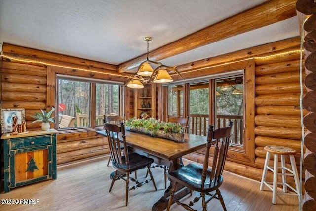 dining space featuring hardwood / wood-style flooring, log walls, a notable chandelier, and beam ceiling