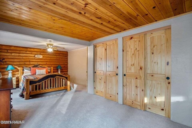 carpeted bedroom featuring wooden ceiling, rustic walls, and multiple closets