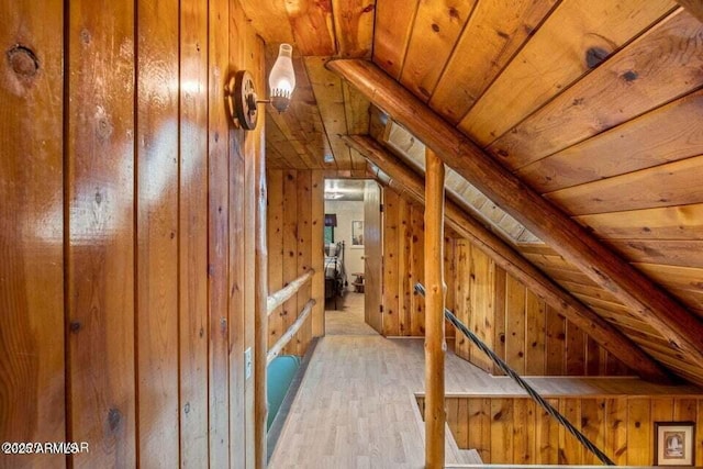 additional living space featuring wood ceiling, wood walls, lofted ceiling, and light wood-style flooring