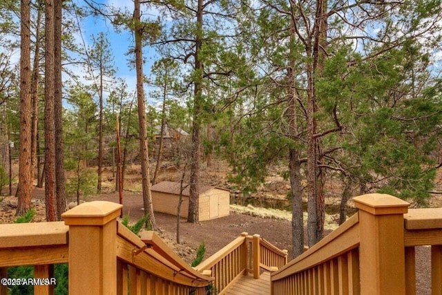 wooden deck featuring an outdoor structure and a storage unit