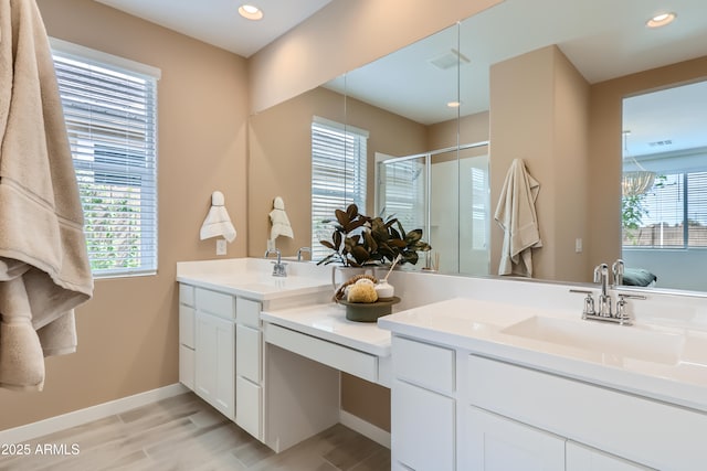 full bathroom featuring a stall shower, plenty of natural light, vanity, and baseboards