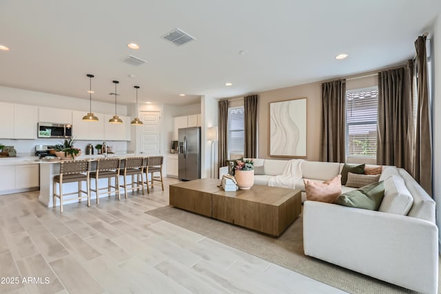 living room featuring recessed lighting and visible vents