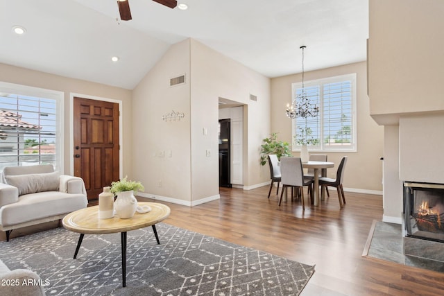 living room featuring wood finished floors, a chandelier, baseboards, ceiling fan, and recessed lighting