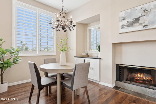 dining area featuring dark wood-style flooring, a chandelier, and healthy amount of natural light
