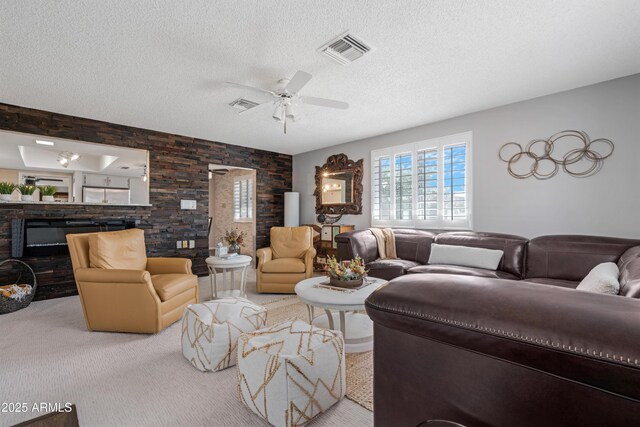 9621 E Calgary Ave, Sun Lakes, AZ 85248 - living room with a textured ceiling, ceiling fan, carpet, and a glass covered fireplace