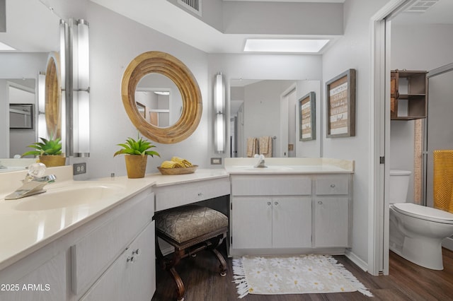9621 E Calgary Ave, Sun Lakes, AZ 85248 - bathroom with wood finished floors, toilet, vanity, and baseboards