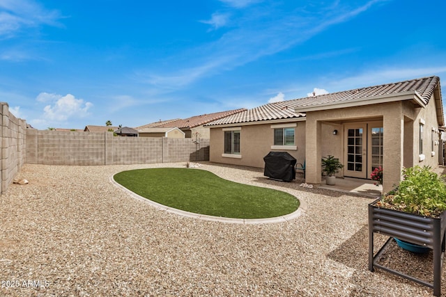 1874 E Mesquite Ave, Apache Junction, AZ 85119 - back of house featuring stucco siding, a tiled roof, a fenced backyard, and a patio