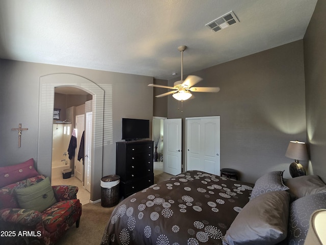 carpeted bedroom featuring ensuite bathroom and ceiling fan