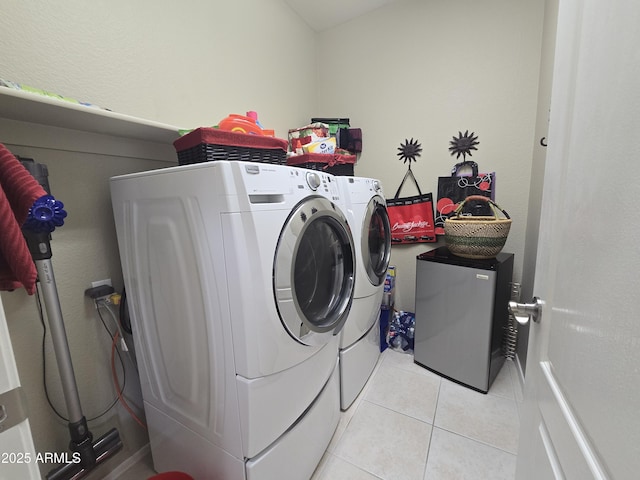 clothes washing area featuring light tile patterned floors and washer and clothes dryer