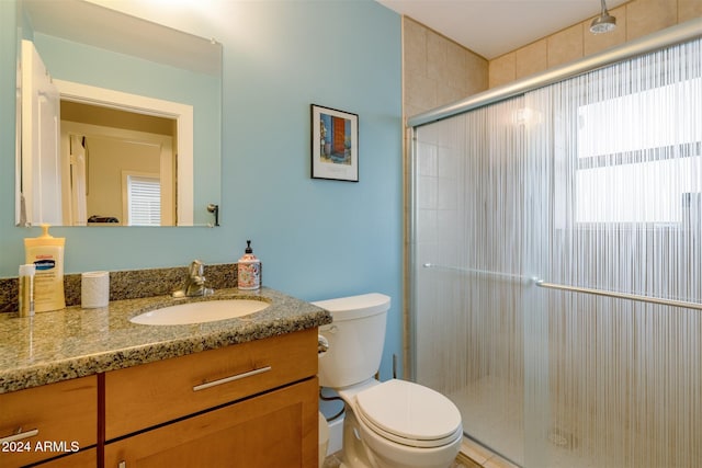 bathroom with vanity, toilet, and an enclosed shower