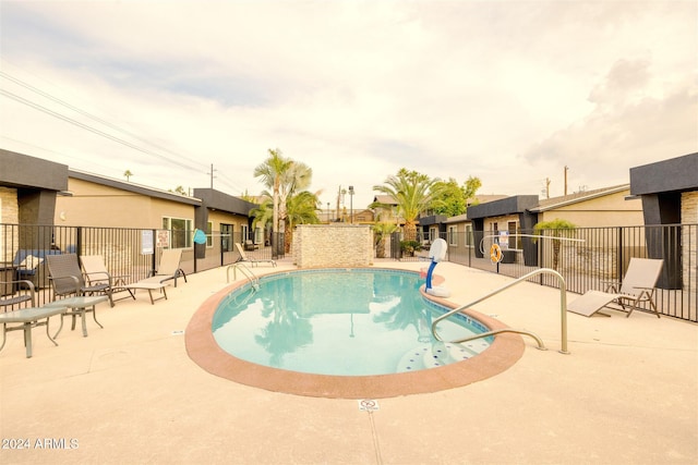 view of pool featuring pool water feature and a patio