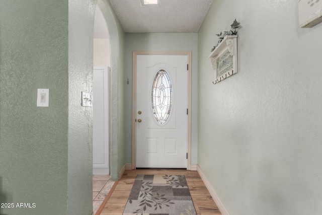 2003 W Tyson St, Chandler, AZ 85224 - doorway with baseboards, arched walkways, light wood finished floors, and a textured wall