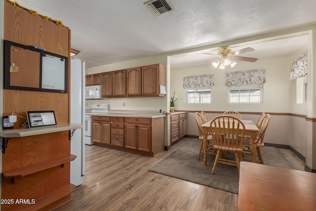 2003 W Tyson St, Chandler, AZ 85224 - kitchen featuring a ceiling fan, visible vents, brown cabinets, light wood-style floors, and white appliances