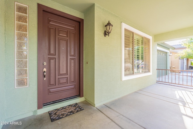 view of exterior entry featuring a garage and covered porch