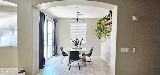 4705 E Red Oak Ln Unit 101, Gilbert, AZ 85297 - dining room featuring arched walkways, light wood finished floors, and a chandelier